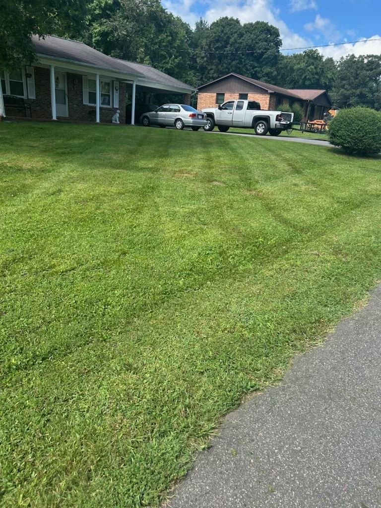 Quality Lawn & Landscape work truck parked beside a freshly mowed yard in Wilkes County, NC